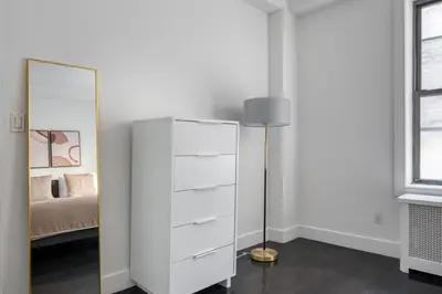 a white dresser in a bedroom with a mirror at Midtown 2br w doorman wd nr Central Park NYC-1246 in New York