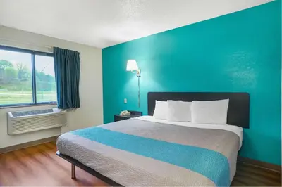 a bedroom with a large bed with a blue wall at Motel 6-Montoursville, PA - Williamsport in Williamsport