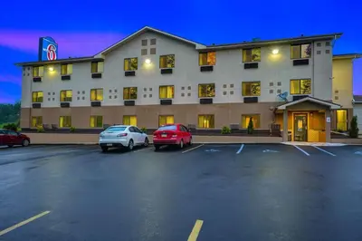 a hotel with two cars parked in a parking lot at Motel 6-Montoursville, PA - Williamsport in Williamsport