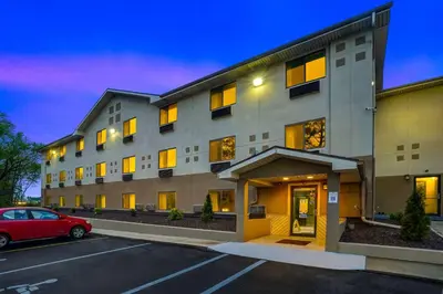 a building with a red car parked in a parking lot at Motel 6-Montoursville, PA - Williamsport in Williamsport