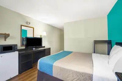 a hotel room with a bed and a flat screen tv at Motel 6-Montoursville, PA - Williamsport in Williamsport
