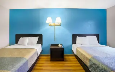 two beds in a room with a blue wall at Motel 6-Montoursville, PA - Williamsport in Williamsport