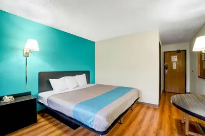 a bedroom with a bed with a blue wall at Motel 6-Montoursville, PA - Williamsport in Williamsport
