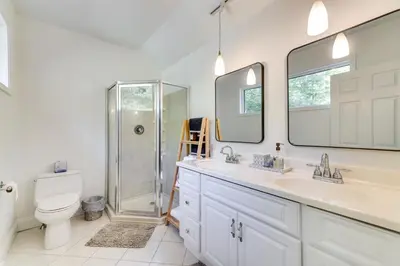a bathroom with a shower and two sinks and a toilet at Pocono Pines Gem with Fire Pit and On-Site Creek! in Pocono Pines