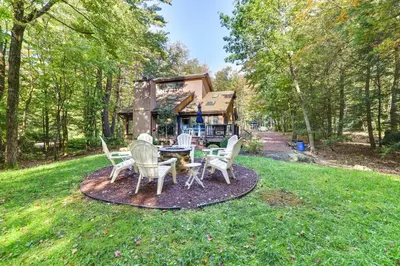 a patio with a table and chairs in a yard at Pocono Pines Gem with Fire Pit and On-Site Creek! in Pocono Pines