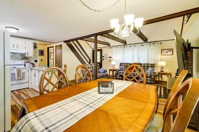 a kitchen and dining room with a wooden table and chairs at Hike, Swim, Ski and More Home in Arrowhead Lakes! in Pocono Lake