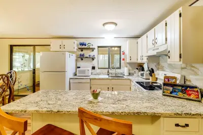 a kitchen with white appliances and a table with chairs at Hike, Swim, Ski and More Home in Arrowhead Lakes! in Pocono Lake