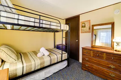 a bedroom with two bunk beds and a dresser at Hike, Swim, Ski and More Home in Arrowhead Lakes! in Pocono Lake