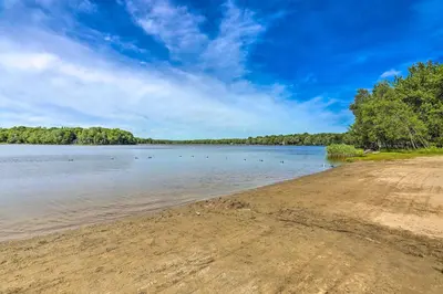 a beach with ducks swimming in the water at Hike, Swim, Ski and More Home in Arrowhead Lakes! in Pocono Lake