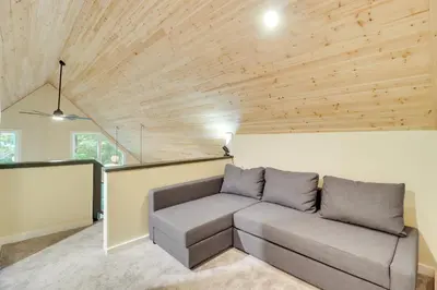 a living room with a couch and wooden ceilings at Community Beach Access Modern Poconos Cabin! in Albrightsville