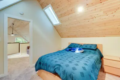 a bedroom with a blue bed with a wooden ceiling at Community Beach Access Modern Poconos Cabin! in Albrightsville