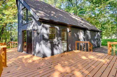 a house with a wooden deck next to a building at Community Beach Access Modern Poconos Cabin! in Albrightsville