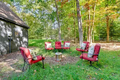 a group of red chairs sitting in the grass at Community Beach Access Modern Poconos Cabin! in Albrightsville