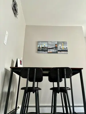 a table with four black bar stools in a room at Iron Bound Gem in Newark