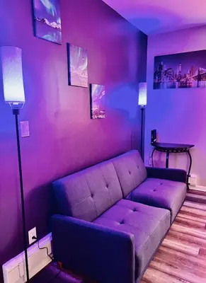 a purple living room with a couch and a table at Iron Bound Gem in Newark