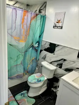a bathroom with a toilet and a shower curtain at Iron Bound Gem in Newark