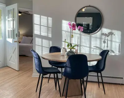 a dining room table with blue chairs and a mirror at Hudson Valley Cottage Rental 3 bedrooms Monroe NY in Monroe