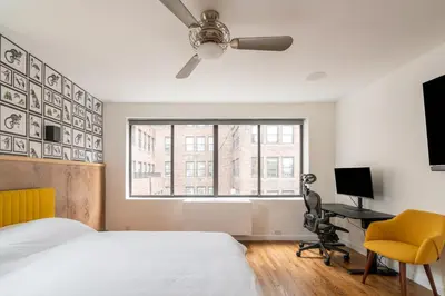 a bedroom with a bed and a desk and a window at Eden, dream high-end home in NYC in New York