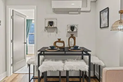 a dining room with a black table and white chairs at 1 BR Passyunk Ave Stunner- Perfect Location in Philadelphia