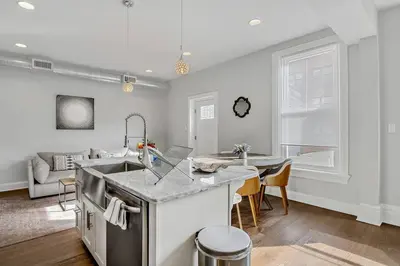 a kitchen with a sink and a living room at Charming HBG Haven: Cozy 1BR Apt in Harrisburg