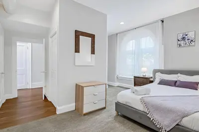 a white bedroom with a bed and a window at Charming HBG Haven: Cozy 1BR Apt in Harrisburg