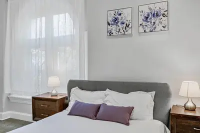 a bedroom with a bed with two night stands and two lamps at Charming HBG Haven: Cozy 1BR Apt in Harrisburg