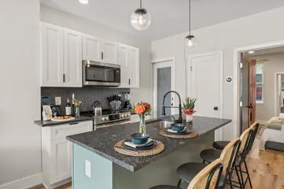 a kitchen with white cabinets and a counter top at Passyunk Square Spacious 1 BR Oasis- Huge Deck in Philadelphia