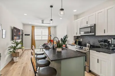 a kitchen with white cabinets and a black counter top at Passyunk Square Spacious 1 BR Oasis- Huge Deck in Philadelphia