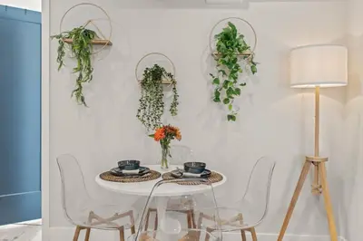 a white table with two chairs and a white wall with plants at E Passyunk Ave 1 BR Gem - Prime Location! in Philadelphia