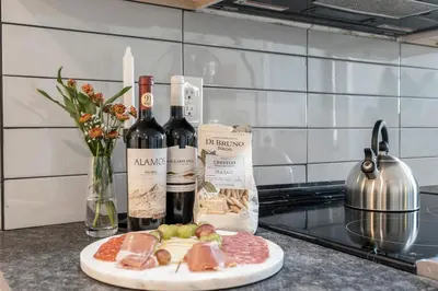 a counter with bottles of wine and a plate of meat at E Passyunk Ave 1 BR Gem - Prime Location! in Philadelphia