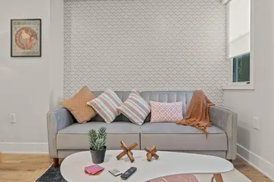a living room with a gray couch with pillows at E Passyunk Ave 1 BR Gem - Prime Location! in Philadelphia