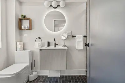 a white bathroom with a sink and a mirror at E Passyunk Ave 1 BR Gem - Prime Location! in Philadelphia