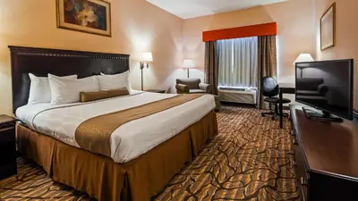 a hotel room with a large bed and a flat screen tv at Best Western Danville Inn in Danville