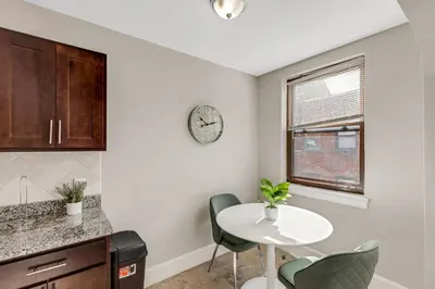 a kitchen with a table and chairs and a clock on the wall at Lennox C201 Furnished Studio ATT Students in Philadelphia