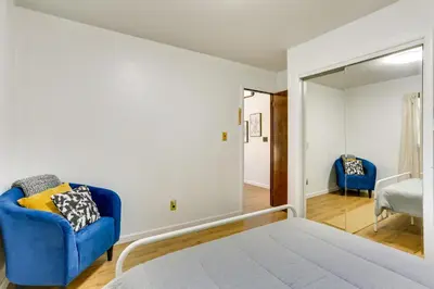 a bedroom with a bed and a blue chair at Glen Spey Cabin with Deck 1 Mi to Mohican Lake! in Glen Spey