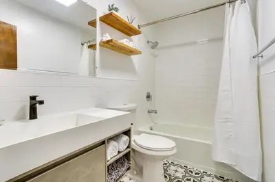 a white bathroom with a toilet and a sink at Glen Spey Cabin with Deck 1 Mi to Mohican Lake! in Glen Spey