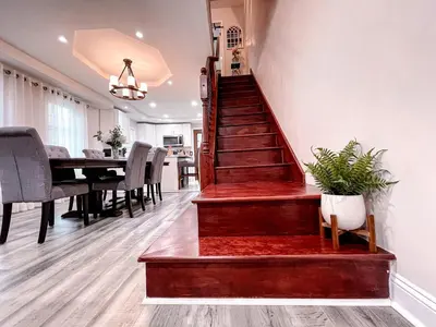 a staircase in a living room with a dining room table at Cheerful & Modern Home w/ a Walkout Deck Area in Glenside