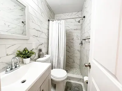 a white bathroom with a toilet and a sink at Cheerful & Modern Home w/ a Walkout Deck Area in Glenside
