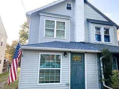 a house with an american flag in front of it at Cheerful & Modern Home w/ a Walkout Deck Area in Glenside