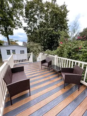 a wooden deck with benches and chairs on it at Cheerful & Modern Home w/ a Walkout Deck Area in Glenside