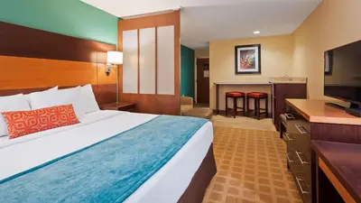 a hotel room with a bed and a flat screen tv at Best Western Plus Harrisburg Mechanicsburg in Enola
