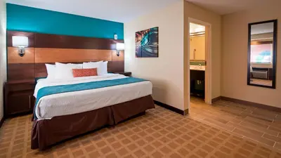 a bedroom with a large bed and a bathroom at Best Western Plus Harrisburg Mechanicsburg in Enola