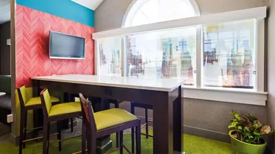 a bar in a room with chairs and a tv at Best Western Plus Harrisburg Mechanicsburg in Enola