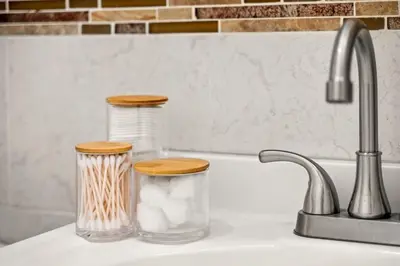 a kitchen sink with two glass containers with wooden tops at Charming Home In Heart of City With King Size Bed! in Philadelphia