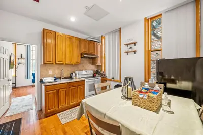 a kitchen with wooden cabinets and a table in a room at Charming Home In Heart of City With King Size Bed! in Philadelphia