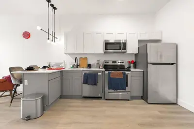 a kitchen with white cabinets and stainless steel appliances at Elegant Bd,EWR AIRPT,Nyc, Free Pkng, Prudential CNTR, American Dream Mall in Elizabeth
