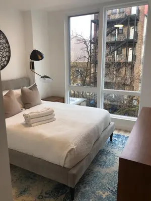 a bedroom with a bed and a large window at Modern 3BR Lofts with Outdoor Space Near NYC in Hoboken