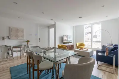 a living room with a glass table and chairs at Modern 3BR Lofts with Outdoor Space Near NYC in Hoboken
