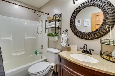 a bathroom with a sink and a toilet and a mirror at Hot Tub, Deck and Game Room Spacious Poconos Escape in Stroudsburg