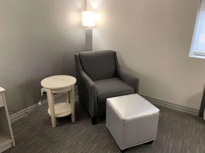 a room with a chair and a stool and a table at Best Western Plus Clarks Summit Scranton Hotel in Clarks Summit